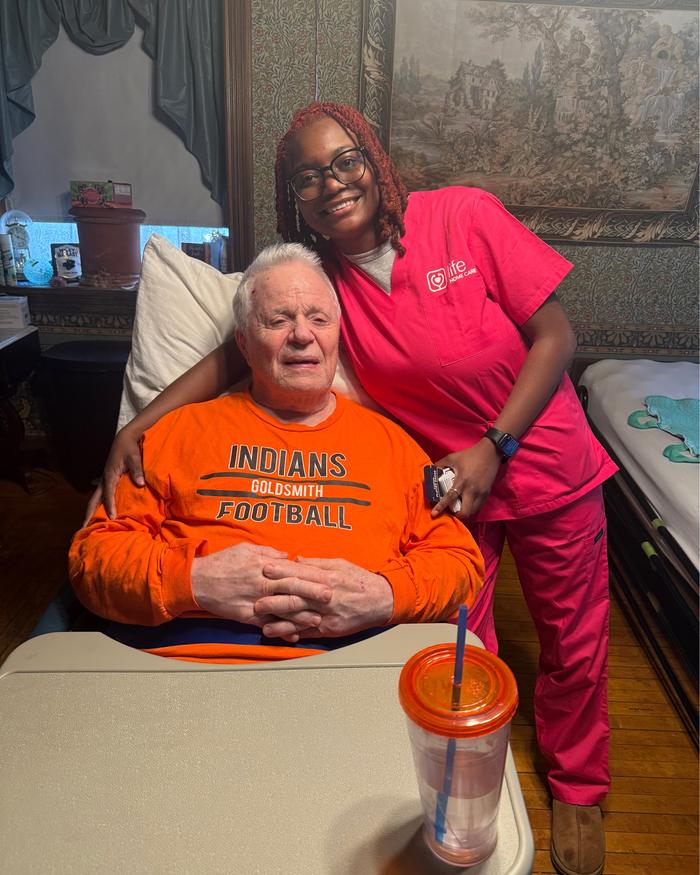 A Life Primary Care clinician with a patient at home, beside the hospital bed set up in his own room