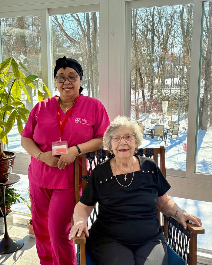 A Life Primary Care clinician standing with a patient in the sunroom of her own home after a visit