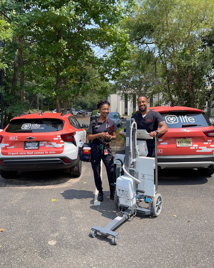 Two Life Primary Care clinicians loading a stair chair between visits